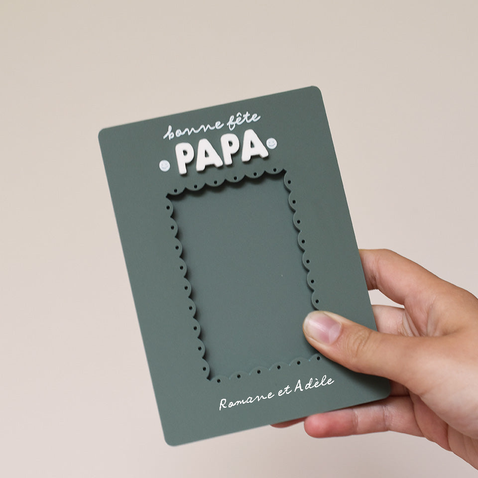 Cadre en plexi, format rectangulaire colors vert « pin » et texte blanc. Découpe de l’ouverture au centre en feston
Inscription en haut centré sur 2 lignes, ligne 1 « bonne fête », ligne 2 « Papa » en relief plexi blanc et sur les côtés du mot 2 smileys imprimés
Inscription en bas de deux prénoms