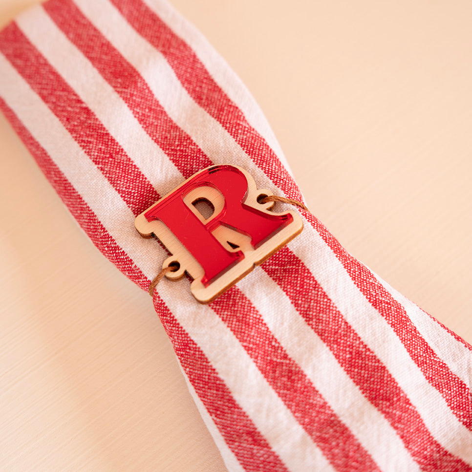 Lettre « R » en bois et relief plexi miroir rouge accroché sur une serviette à rayures blanche et rouge