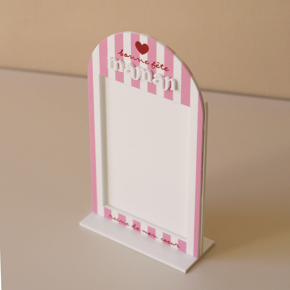Cadre en plexiglass blanc
Modèle rayé rose et texte rouge
Découpe forme arche sur socle blanc
Impression : rayures verticales, partie demi-cercle personnalisé avec inscription sur 3 ligne d’un coeur de « bonne fête » et de « maman ».
Mot « maman » en relief plexi blanc
Inscription sur le bas du cadre de la phrase « reine de mon coeur » (phrase personnalisable)
Ouverture cadre rectangulaire