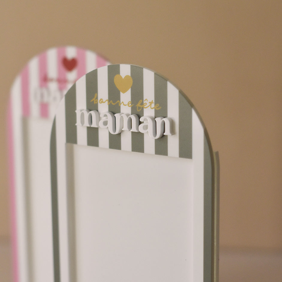 Cadre en plexiglass blanc
Modèle rayé vert et texte doré
Découpe forme arche sur socle blanc
Impression : rayures verticales, partie demi-cercle personnalisé avec inscription sur 3 ligne d’un coeur de « bonne fête » et de « maman ».
Mot « maman » en relief plexi blanc
Inscription sur le bas du cadre de la phrase « reine de mon coeur » (phrase personnalisable)
Focus inscription et relief