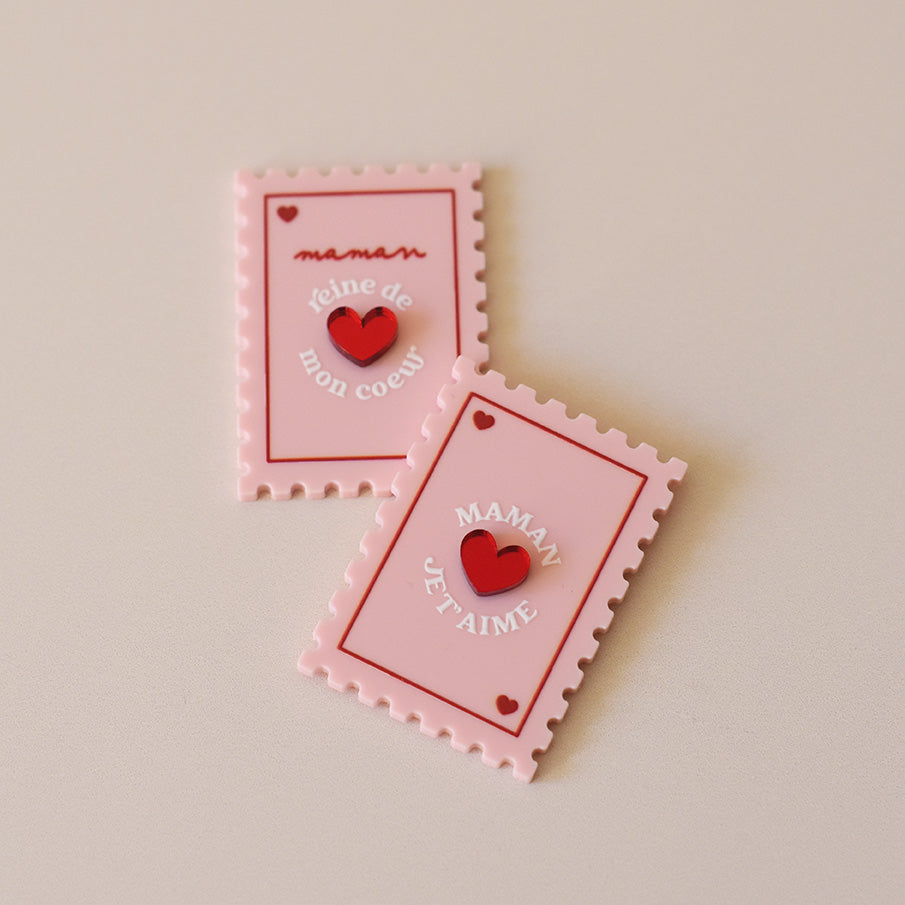 Magnet en plexi coloré rose et rouge, design de carte à jour, forme de timbre et coeur au centre en relief. Inscription maman je t’aime ou reine de mon coeur