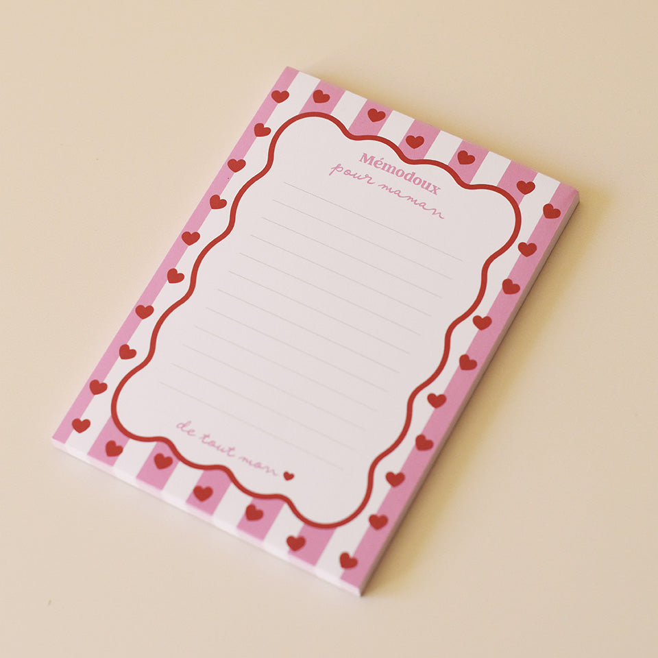 Bloc-notes papier 
Portrait rectangulaire
Modèle cadre rayé rose, contour vague rouge, coeurs rouges
Inscription haut sur 2 lignes « Mémodoux pour maman » 
Inscription bas « jusqu’au étoiles »
12 lignes à intervale réguliers 